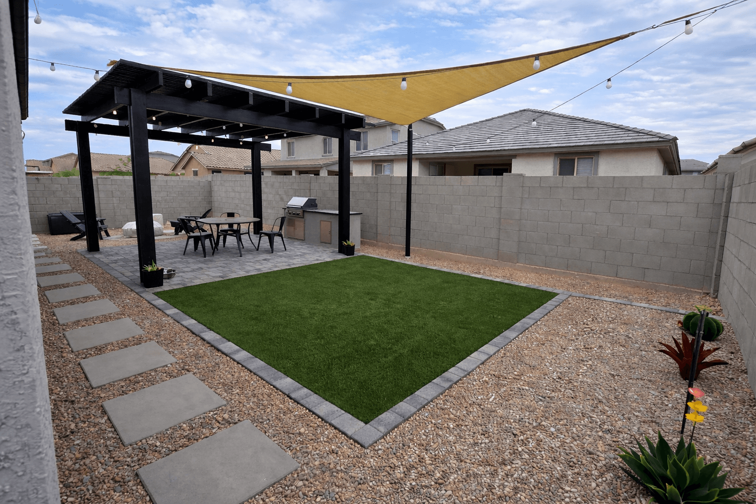 Artificial turf installation with shade sail and paver patio — Gilbert AZ