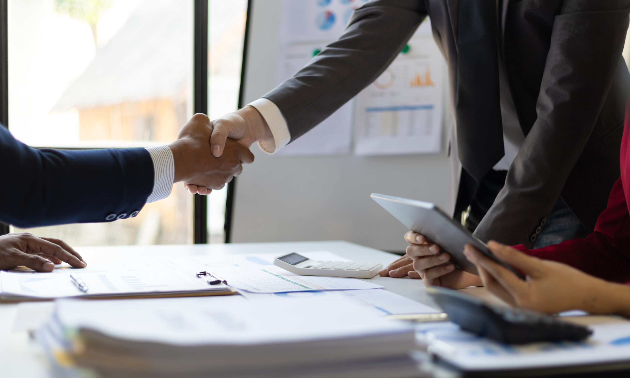 Handshake at the negotiating table representing flexible, win-win real estate negotiations